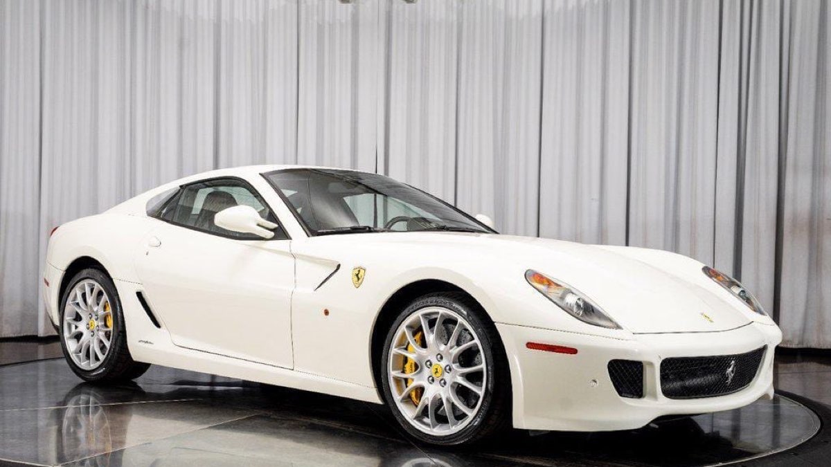 A white Ferrari 599 GTB Fiorano on a dealer showroom floor